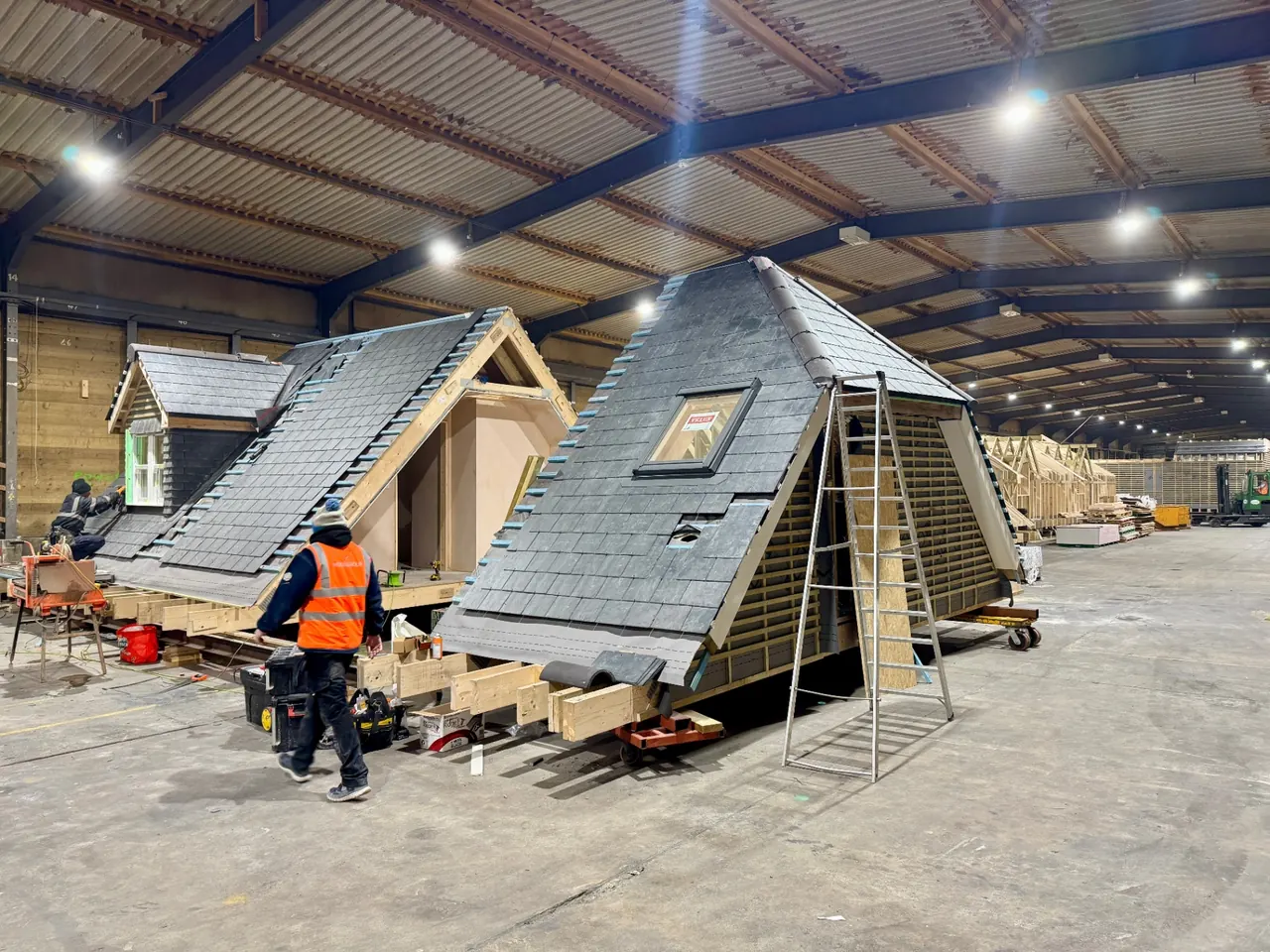 Pair of Moduloft units side by side inside the factory with slate roofs being tiled and VELUX windows fitted